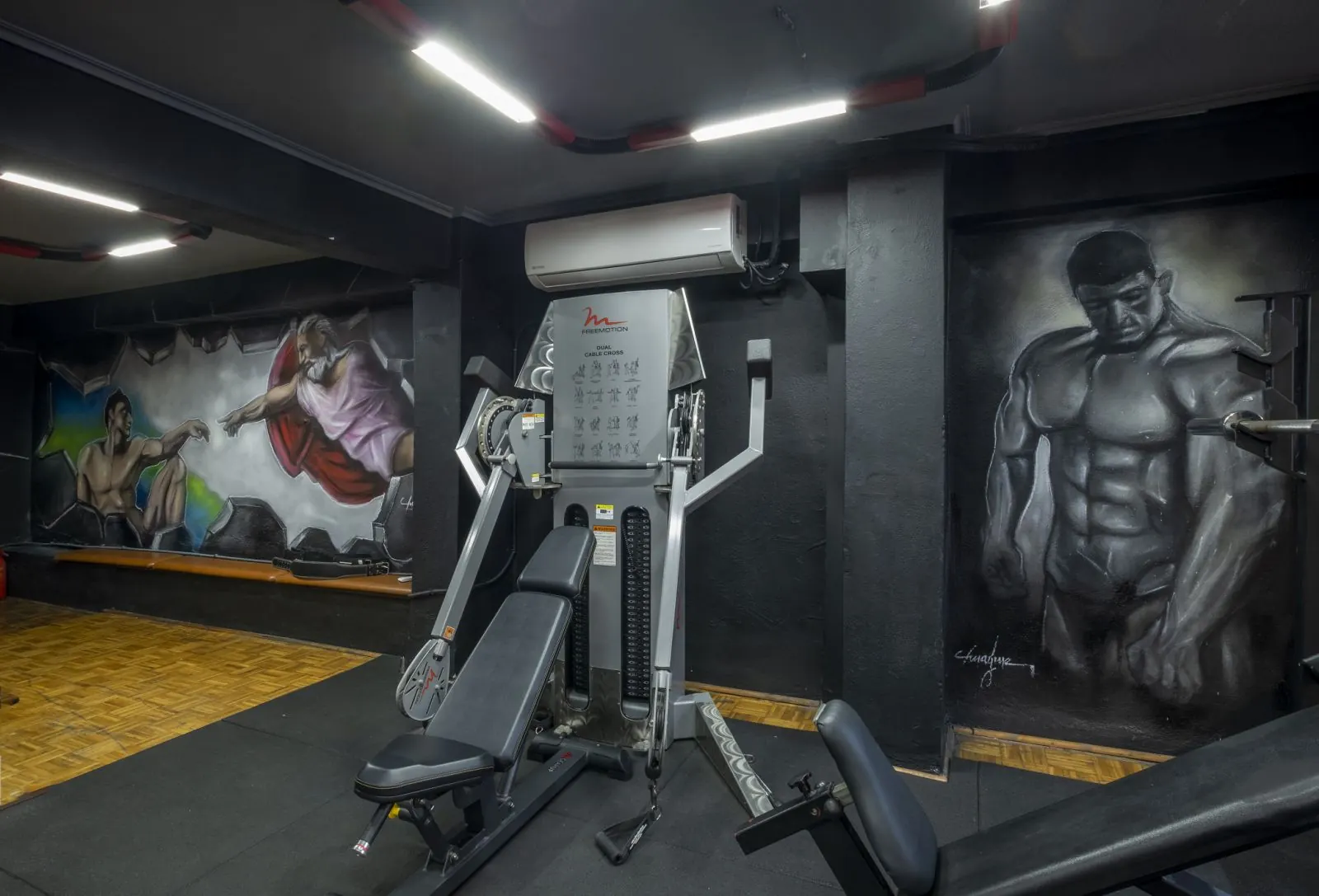 Τοιχογραφίες με bodybuilders δίπλα σε μηχάνημα καλωδίων